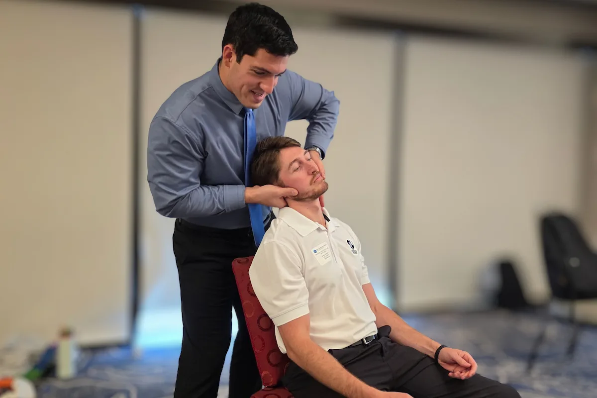 Dr. Zach Weinstein performing a seated neck adjustment at Camel City Chiropractic in Winston-Salem, NC