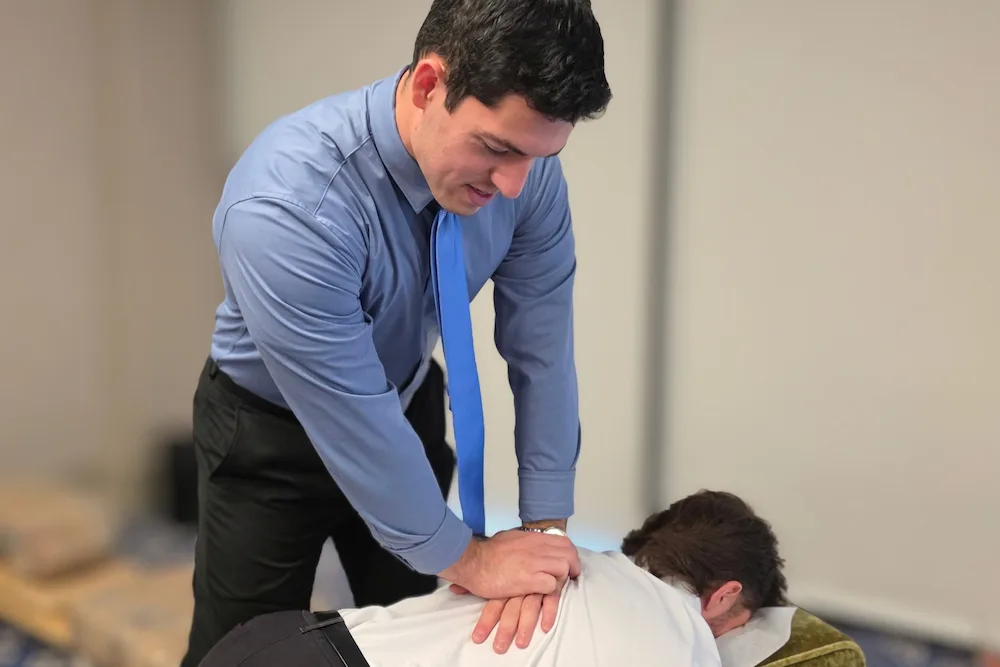 Dr. Zach Weinstein performing a thoracic (mid-back) adjustment at Camel City Chiropractic in Winston-Salem, NC
